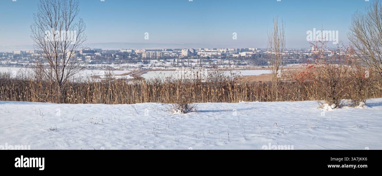 Panoramic view to Ungheni city in Moldova. Beautiful winter scene with frozen Delia lake and the town covered with snow as seen from up a hill - Smartphone Captured Stock Image