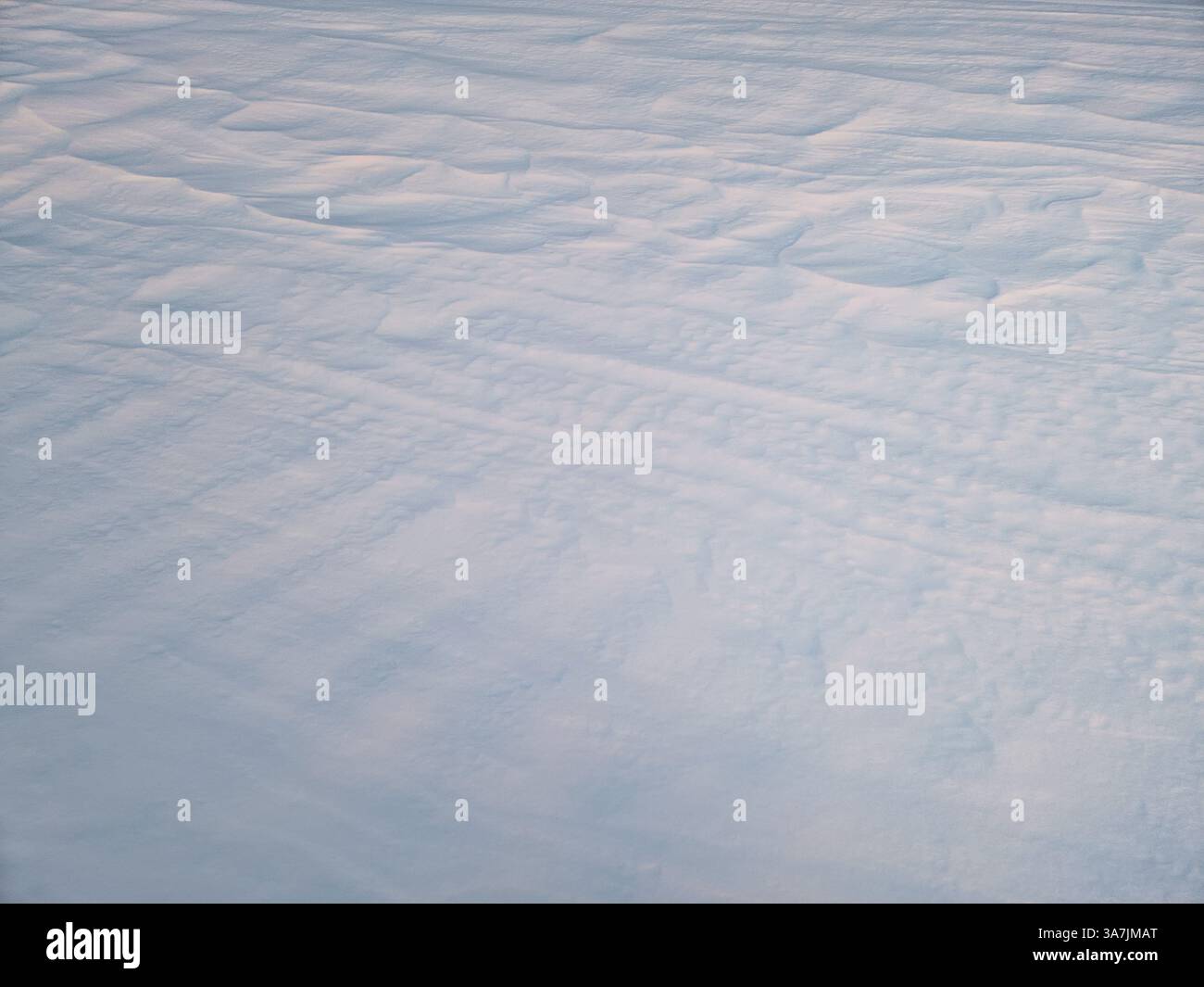 Winter snowdrifts abstract texture of snow shaped by the wind on an empty land in the sunset light - Smartphone Captured Stock Image