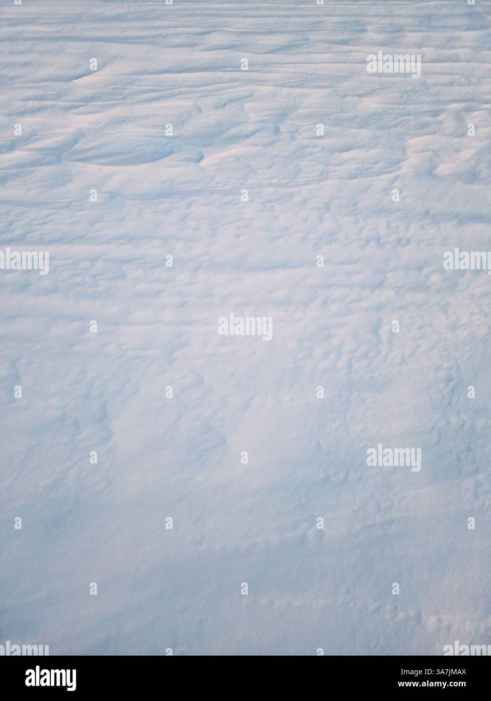 Winter snowdrifts abstract texture of snow shaped by the wind on an empty land in the sunset light - Smartphone Captured Stock Image