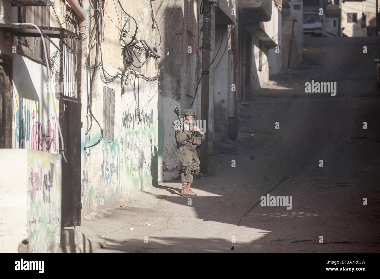 An Israeli soldier takes position during a raid at the Askar refugee ...