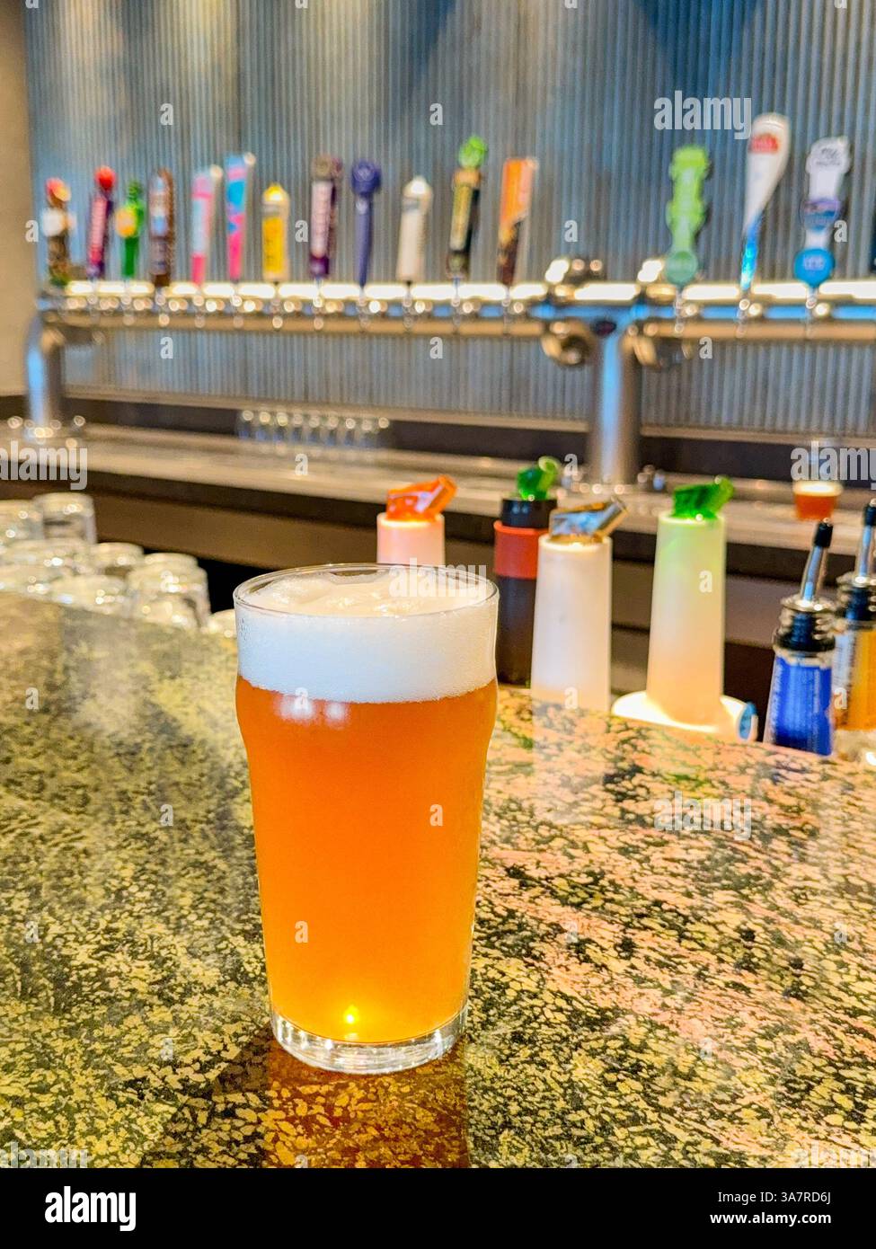 Pint of beer on a bar with beer taps in the background - Smartphone Captured Stock Image