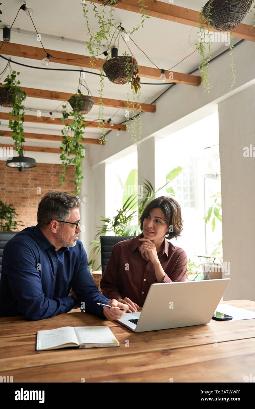 Busy professional executive team managing project using laptop at work. Stock Photo