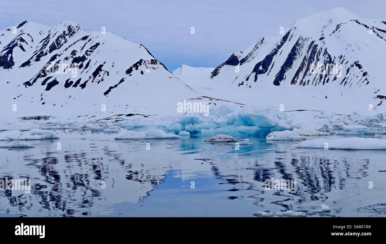 Arctic landscape with azure iceberg and reflections in the undulating ...