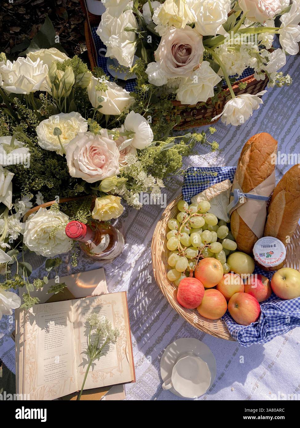 Picnic setting, Flowers, fruit and fresh bread picnic, french inspired picnic - Smartphone Captured Stock Image