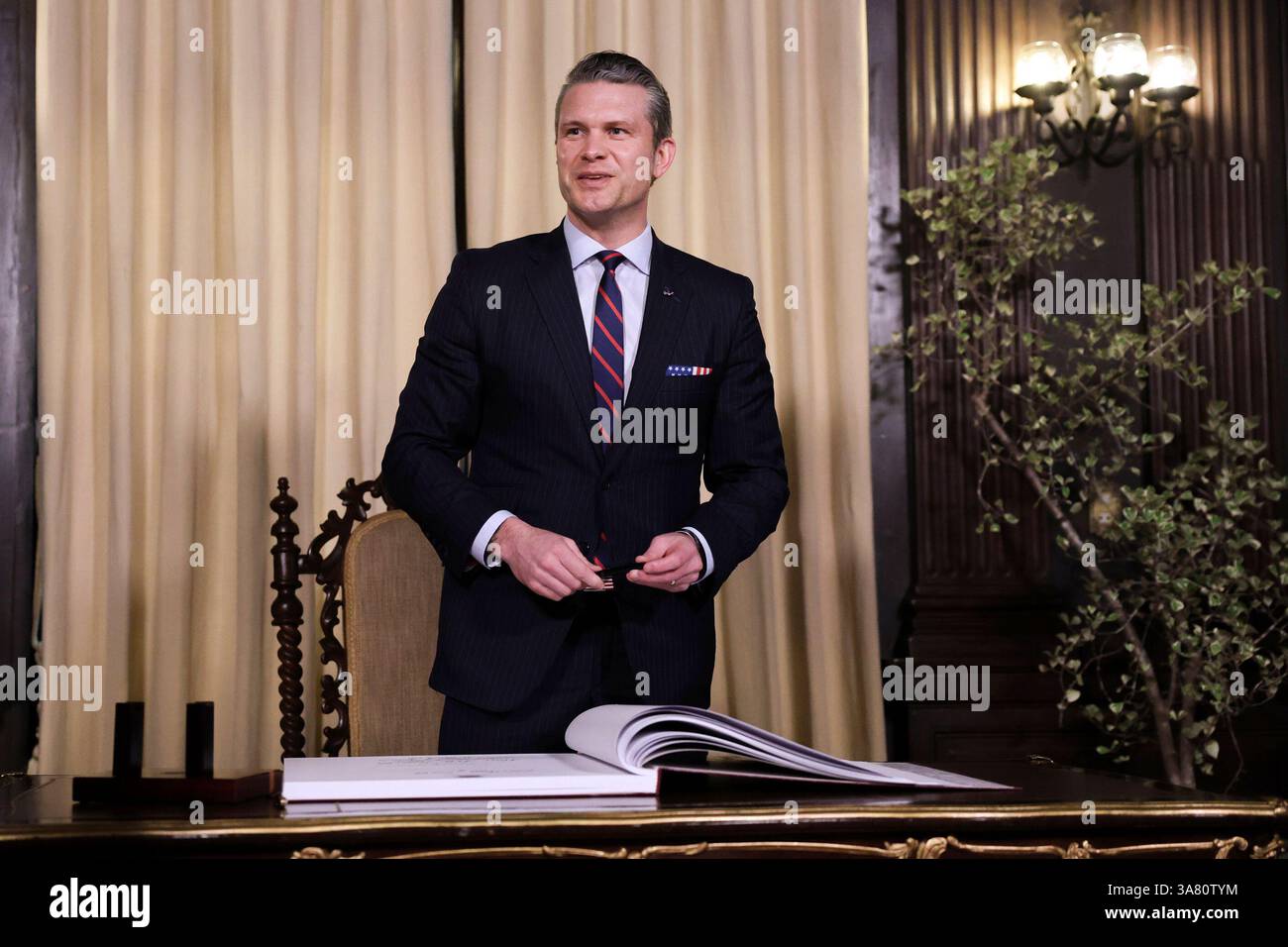 U.S. Defense Secretary Pete Hegseth looks on after signing a guest book ...