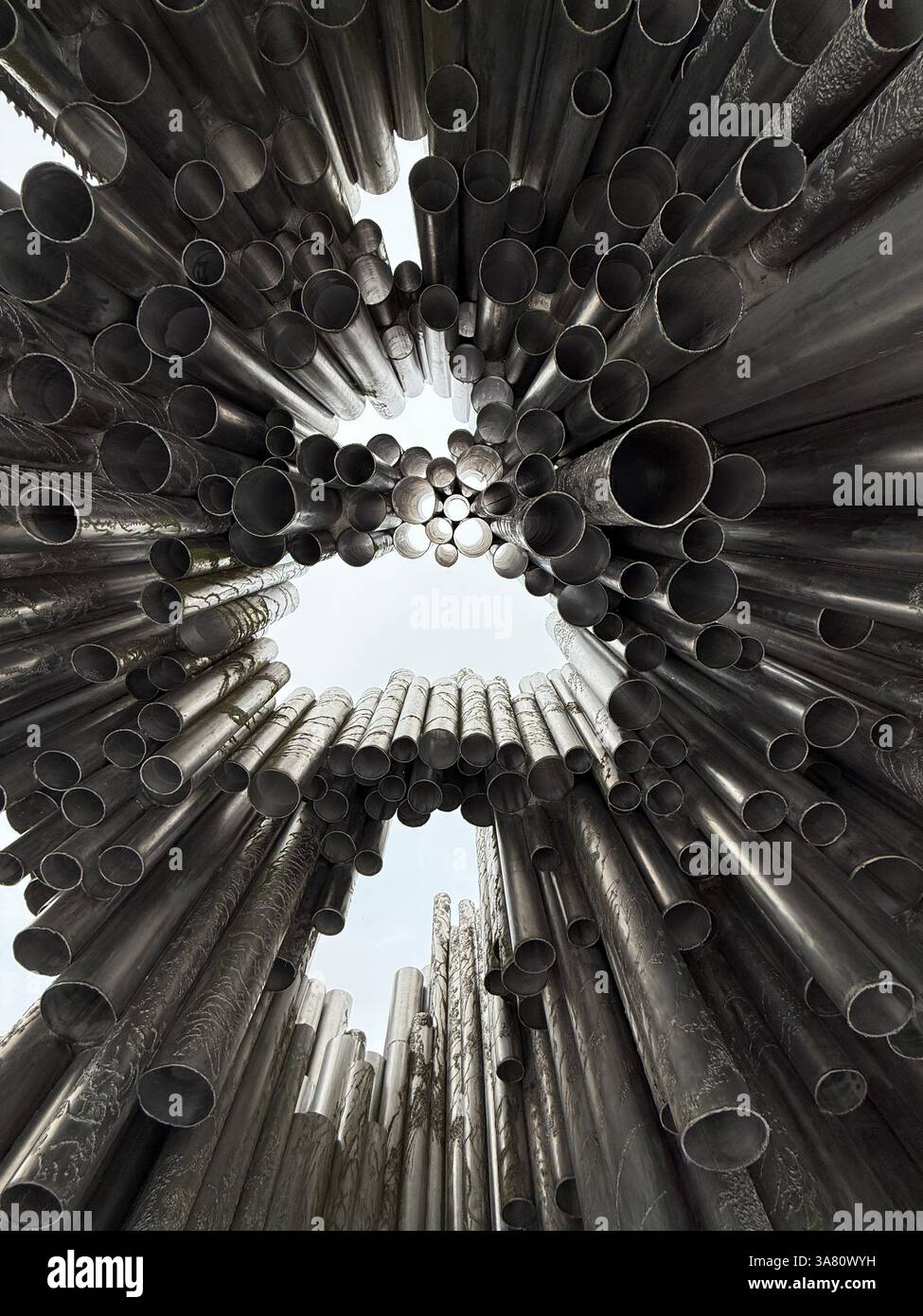 A sculpture composed of numerous metal pipes, creating a striking visual effect when viewed from below. - Smartphone Captured Stock Image