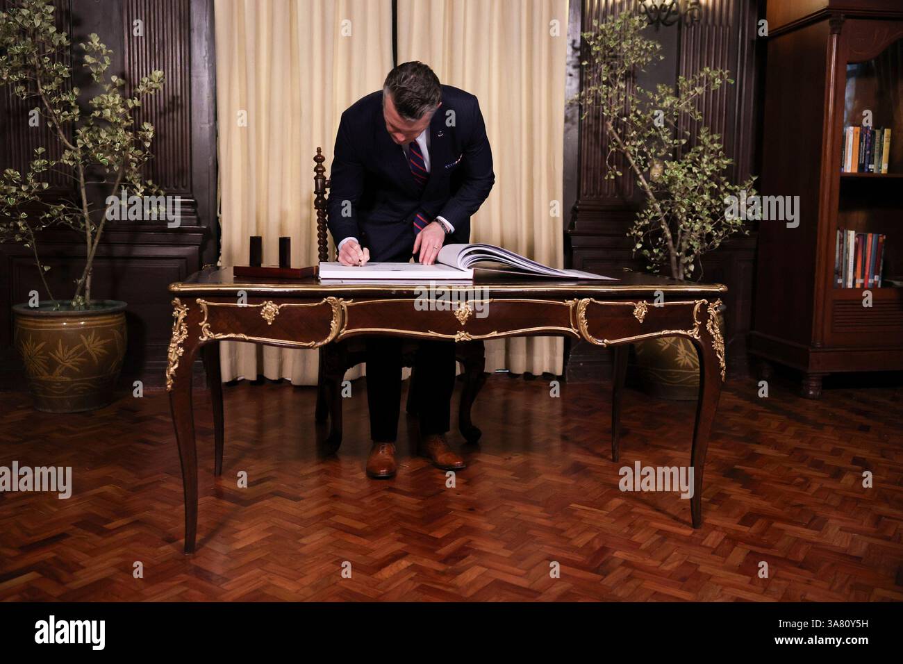 U.S. Defense Secretary Pete Hegseth signs a guestbook at the Malacanang ...