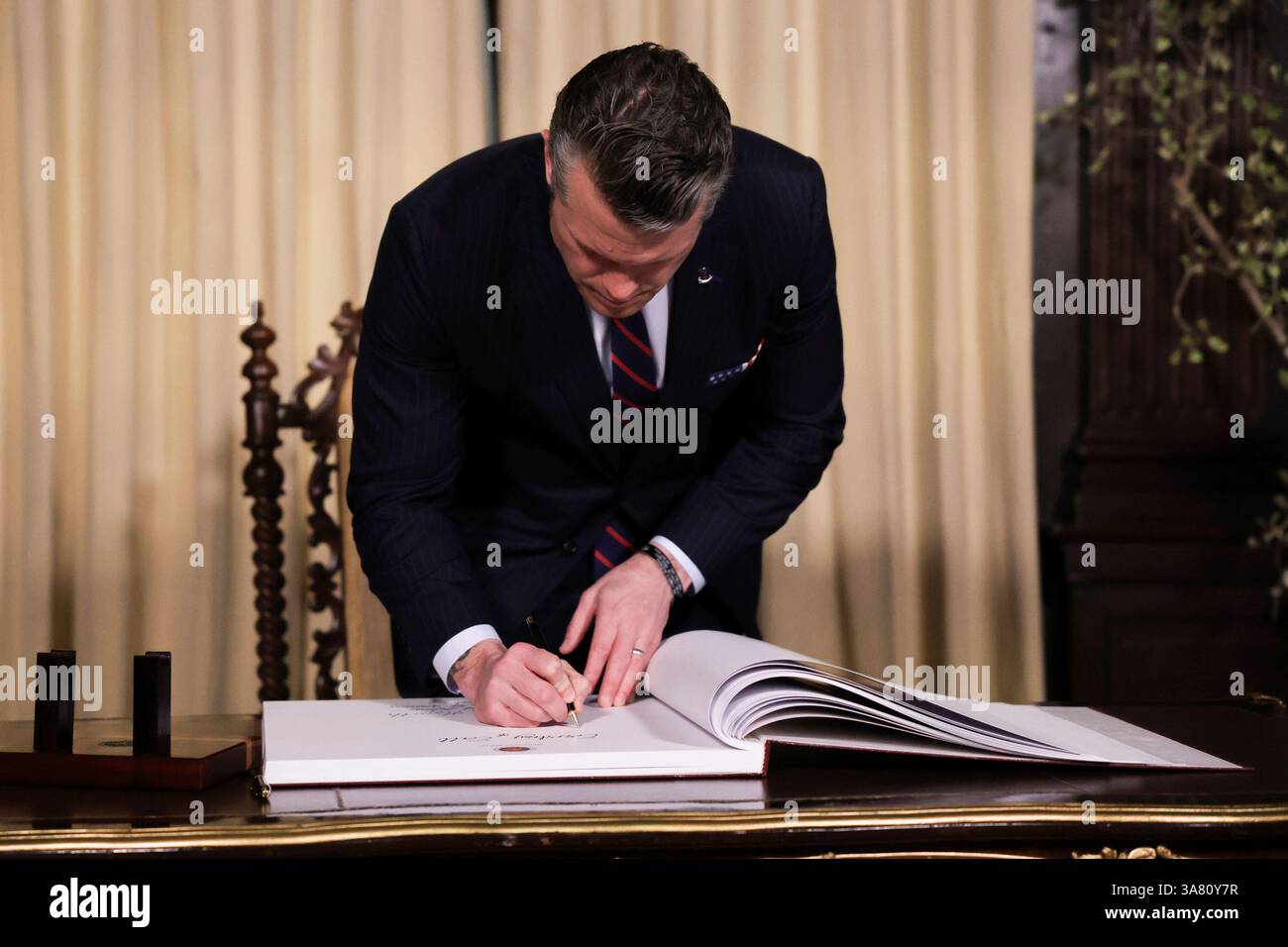 U.S. Defense Secretary Pete Hegseth signs a guestbook at the Malacanang ...