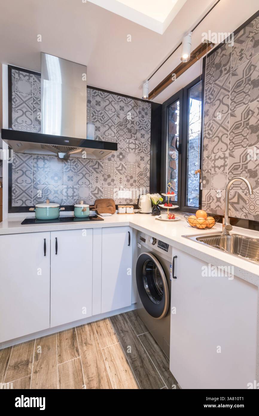 Modern Kitchen with Geometric Tile Backsplash and Integrated Appliances Stock Photo