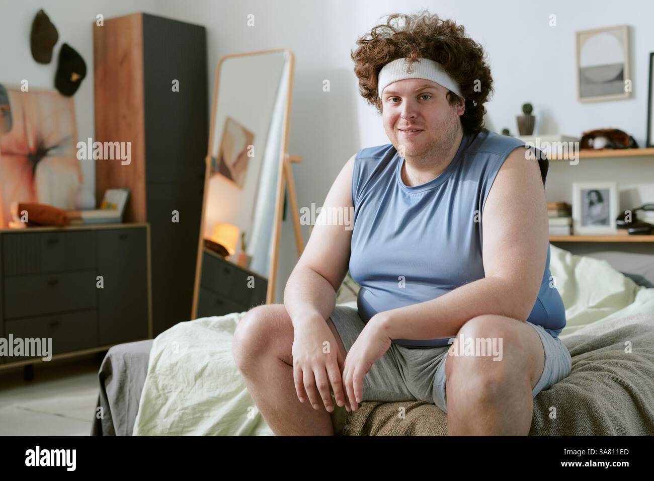 Portrait of Curley-Haired Man Sitting in Relaxed Pose Stock Photo