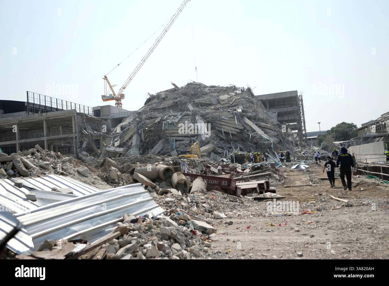 Rescuers work at the site of a high-rise building under construction ...