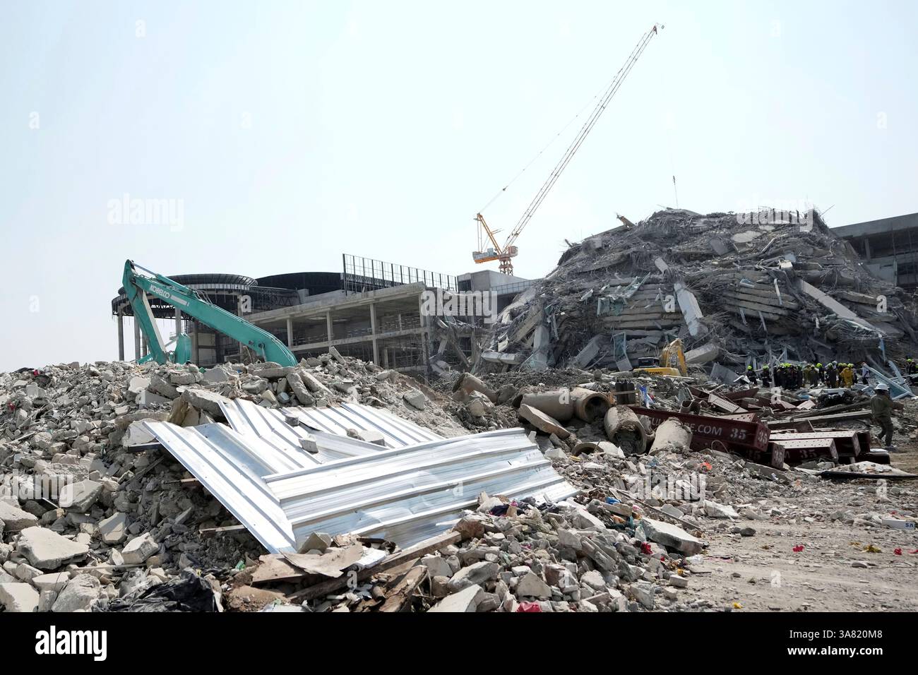 Rescuers work at the site of a high-rise building under construction ...