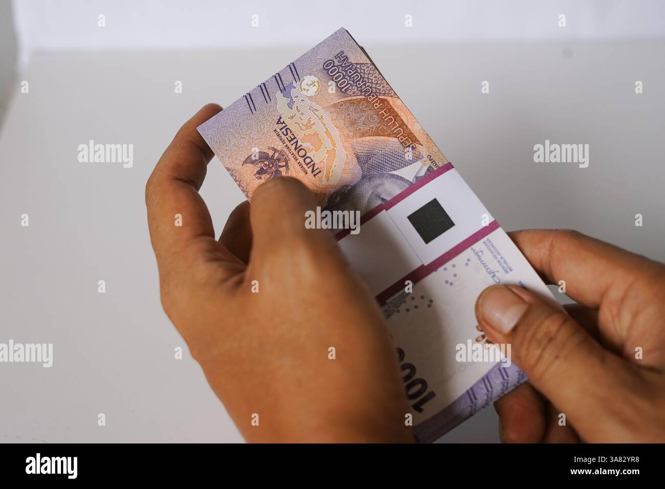 A close-up shot reveals a person's hands handling a neatly stacked ...
