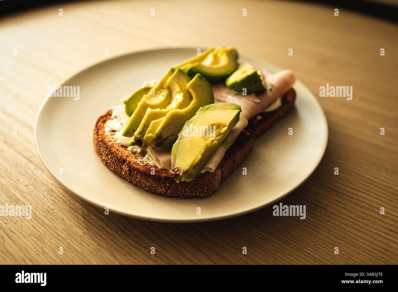 An avocado toasts over a wooden table Stock Photo