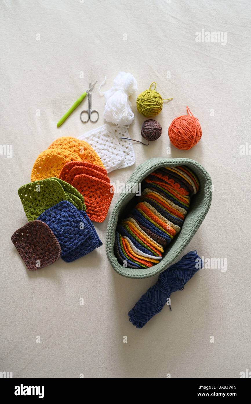 Crocheted squares blanket in making, multi-colored granny square Stock Photo