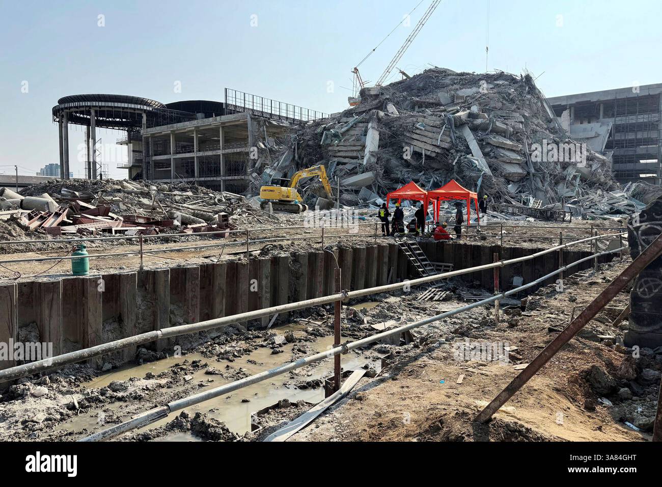 Rescuers work at the site a high-rise building under construction that ...