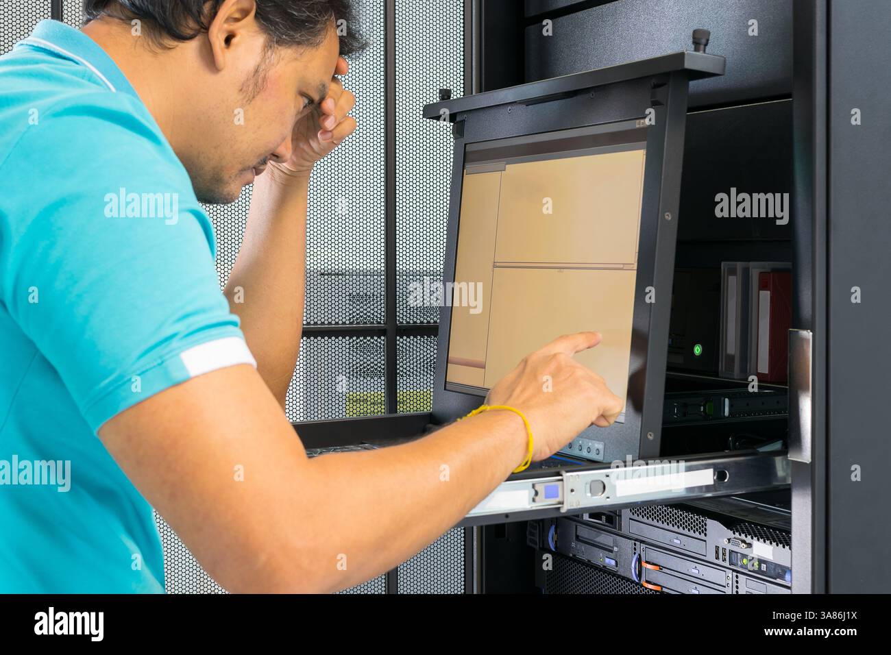 Asia man serious thinking when working on computer server Stock Photo