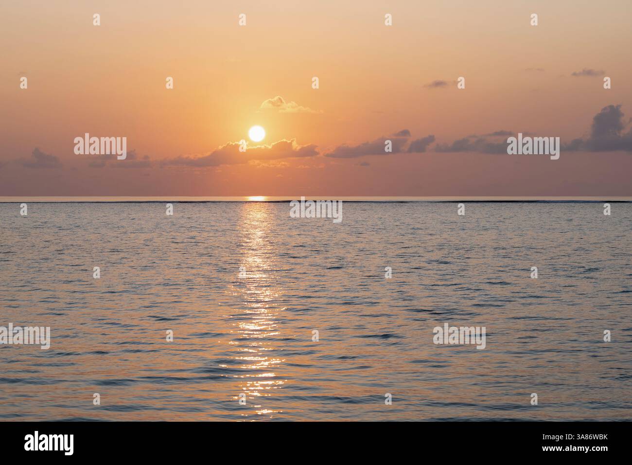 Sunset over the clear waters of the lagoon on an exotic Island in The Maldives, Indian Ocean Stock Photo