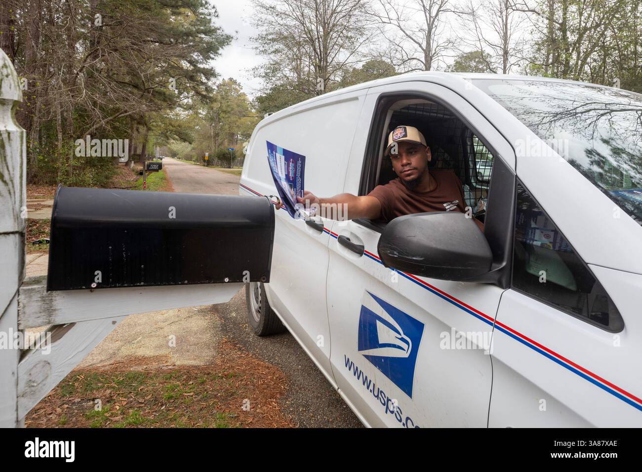 Covington, Louisiana - A letter carrier delivers mail from a U.S. Postal Service vehicle. Stock Photo