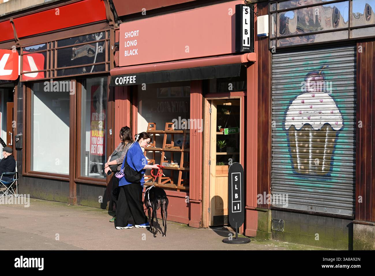 A bustling Victoria Road in the Govanhill area of Glasgow's Southside. Gentrification of a once poor working class neighbourhood . Stock Photo
