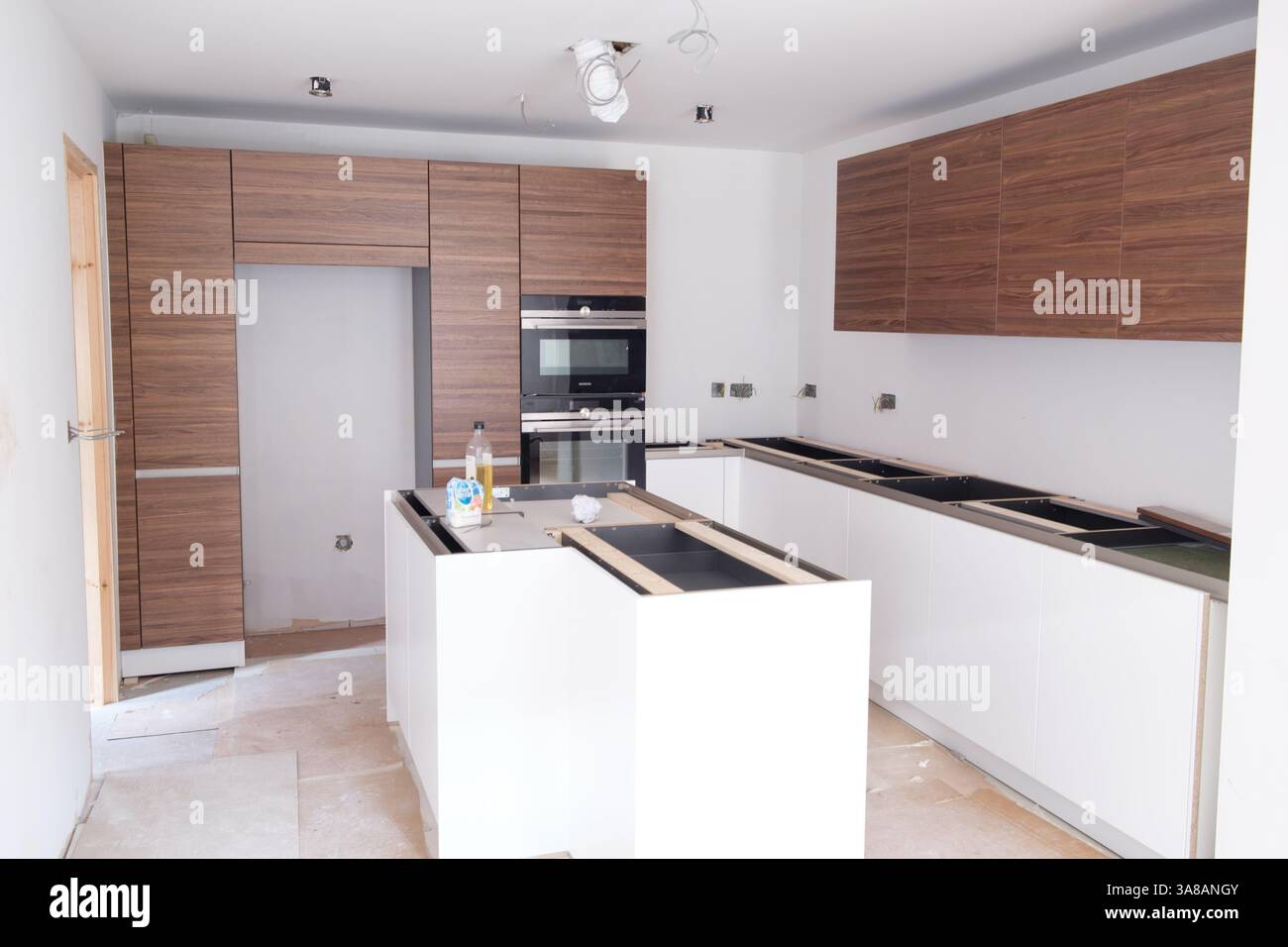 Installation progress on a new kitchen featuring wood-grain and white ...