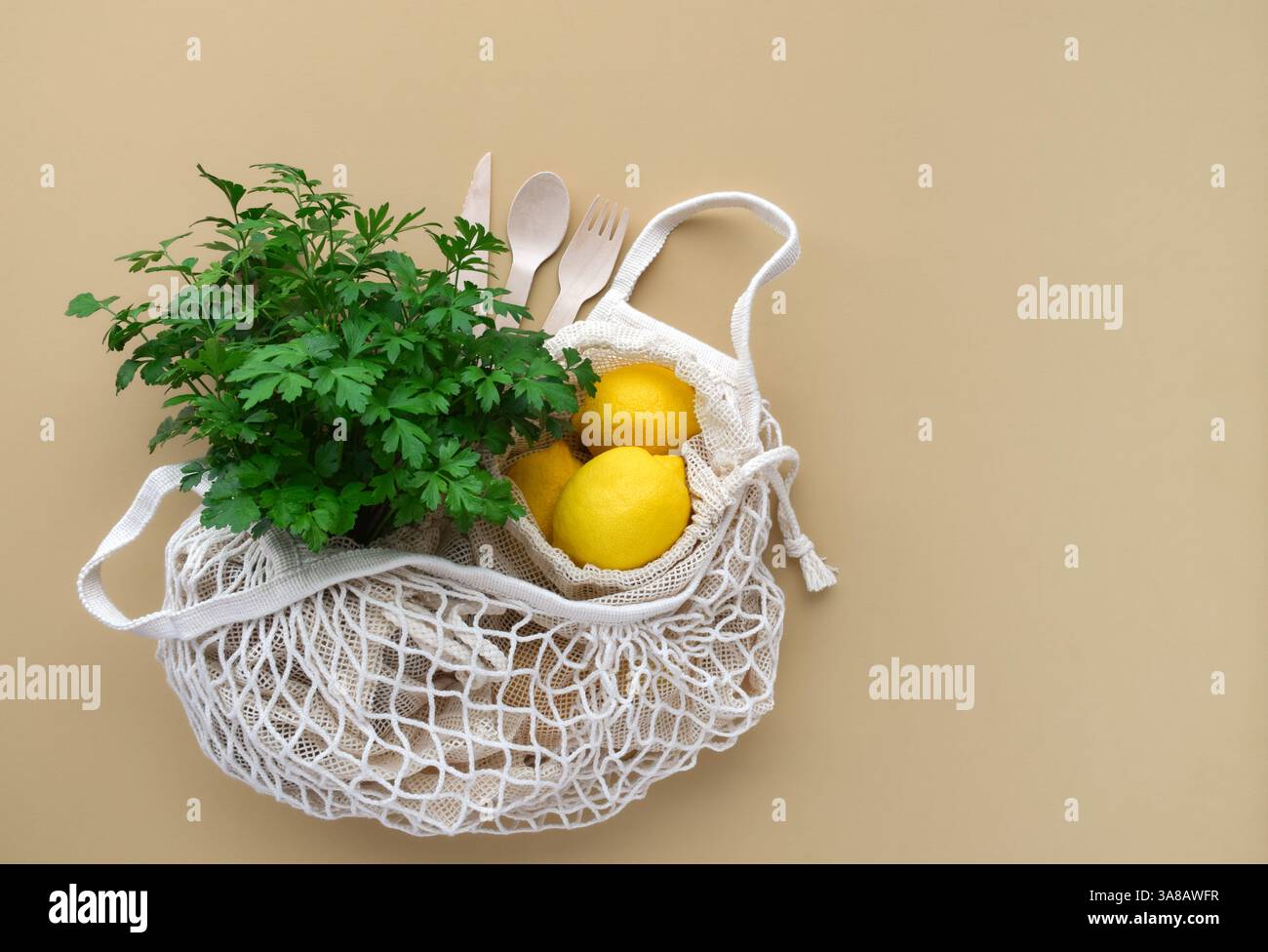 Fresh produce inside reusable mesh shopping bag on beige background with copy space Stock Photo