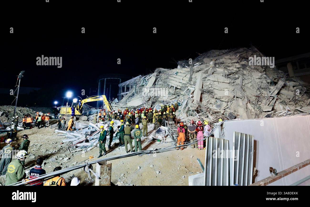 Rescuers work at the site a high-rise building under construction that ...