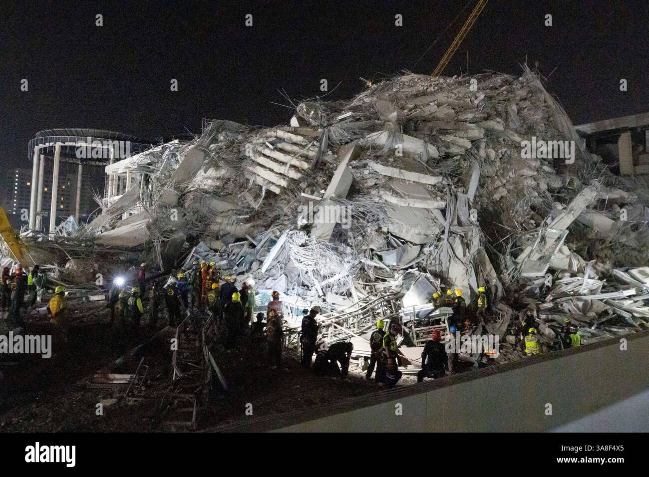 Rescuers search for victims at the site of a high-rise building under ...