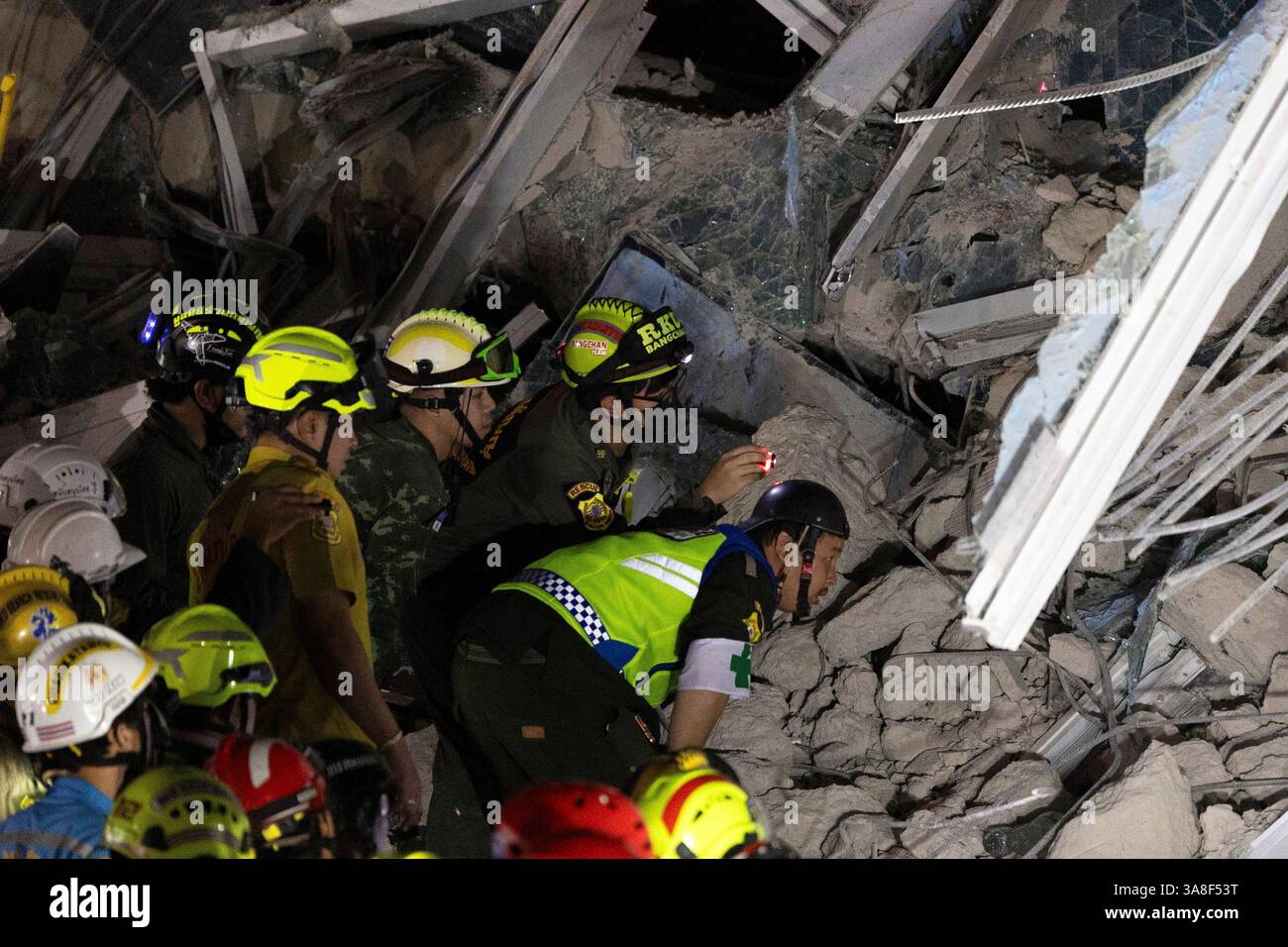Rescuers search for victims at the site of a high-rise building under ...