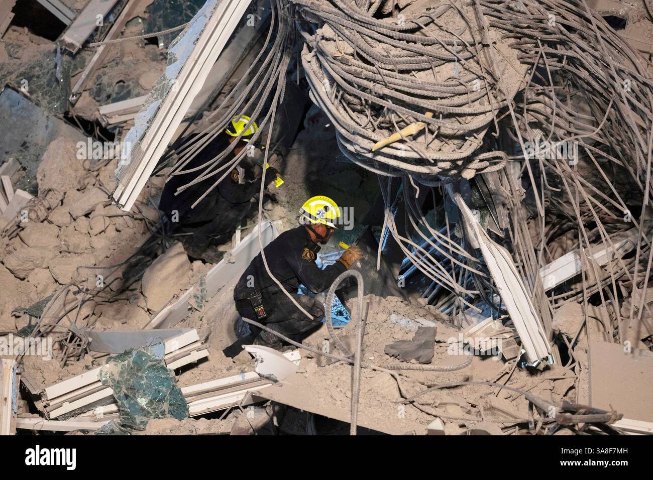 Rescuers search for victims at the site of a high-rise building under ...