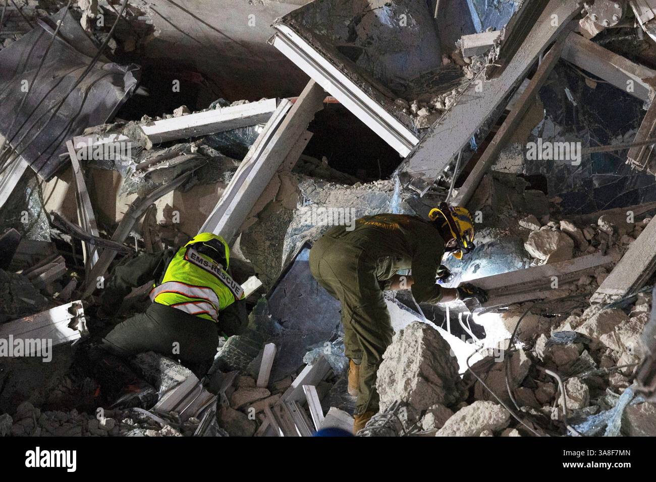 Rescuers search for victims at the site of a high-rise building under ...