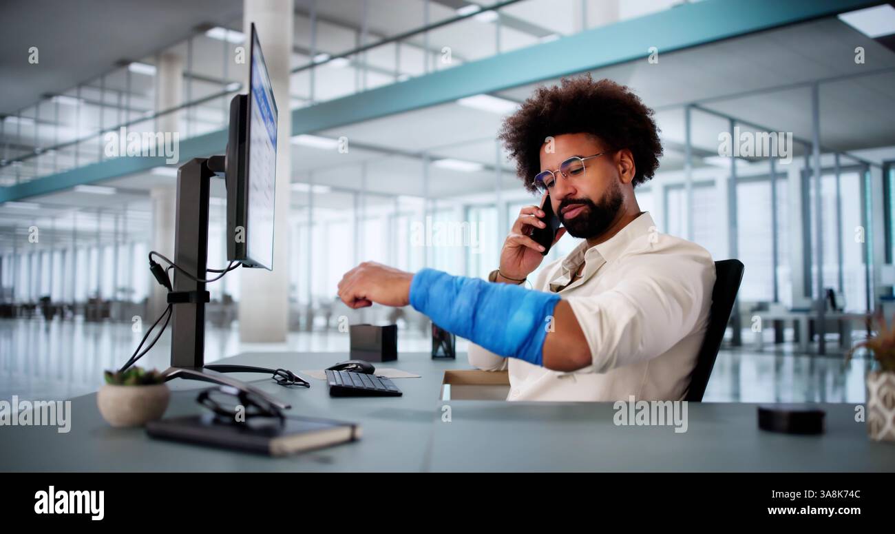 African American man with broken arm calling for worker's compensation. Stock Photo