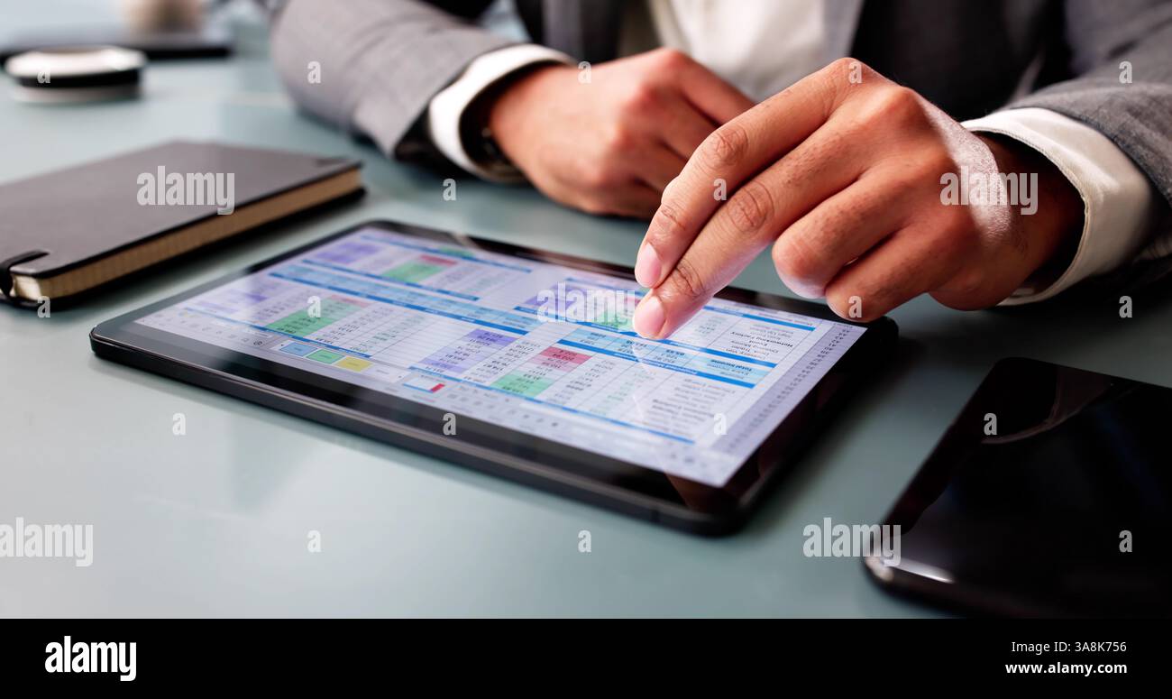 Focused African American man analyzing financial data on computer software. Stock Photo