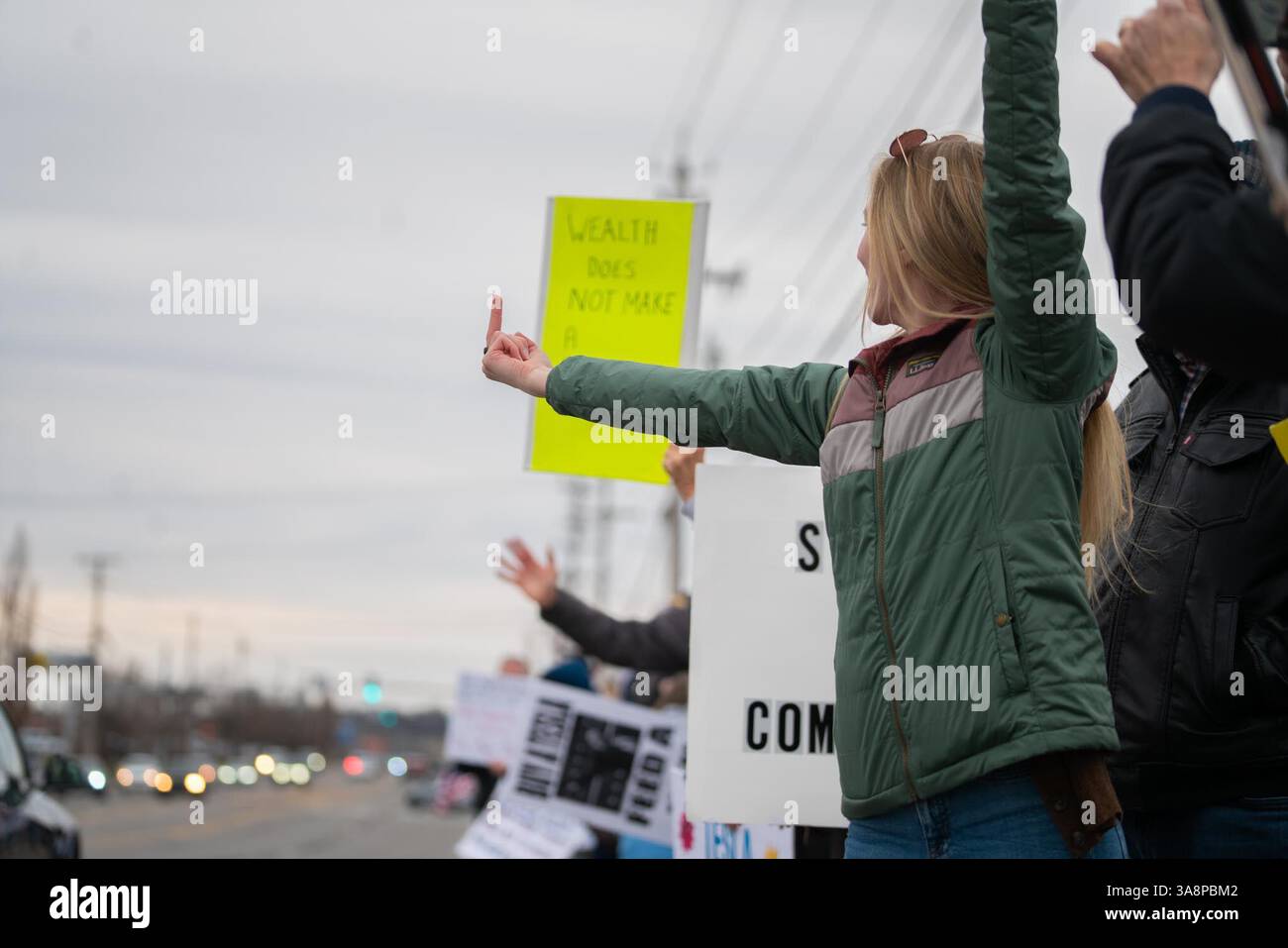 Protesters hold placards as they gather outside Tesla Showroom. A ...