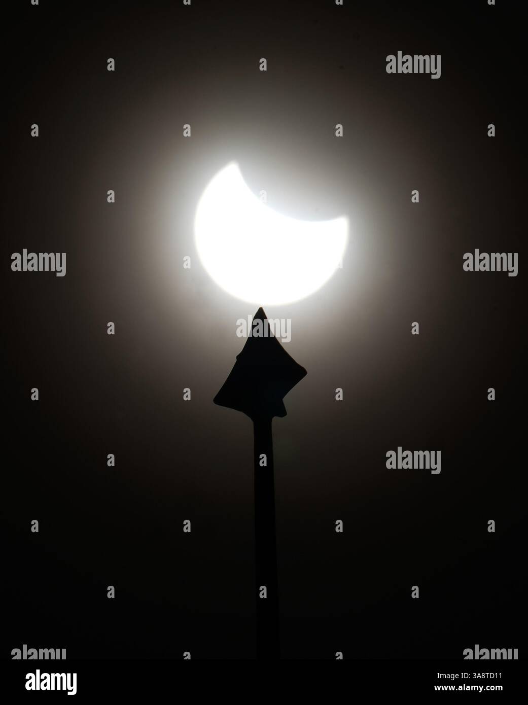 A partial solar eclipse is seen above the roof of the Greenwich foot ...
