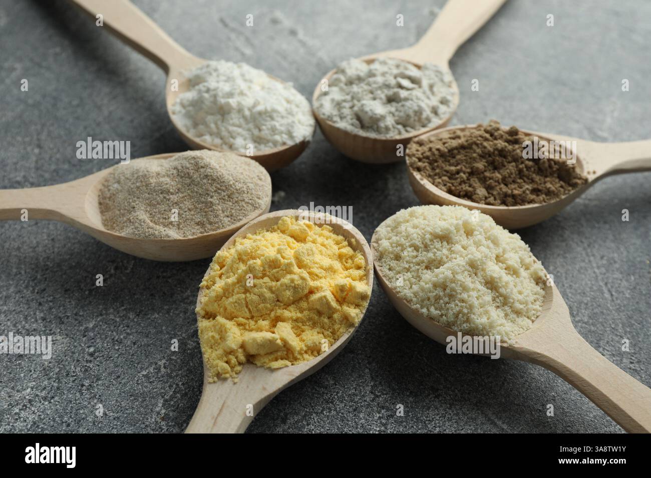 Different types of flour in spoons on grey table, closeup Stock Photo ...