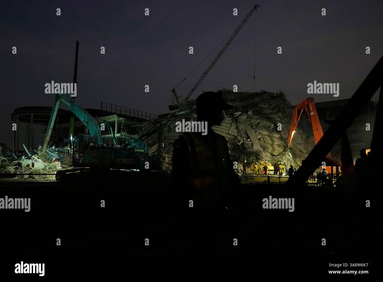 Rescuers work at the site of an under-construction high-rise building ...
