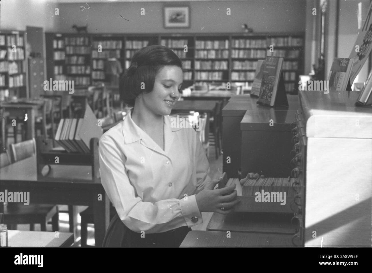 A photograph illustrating the use of a library card catalog, a tool