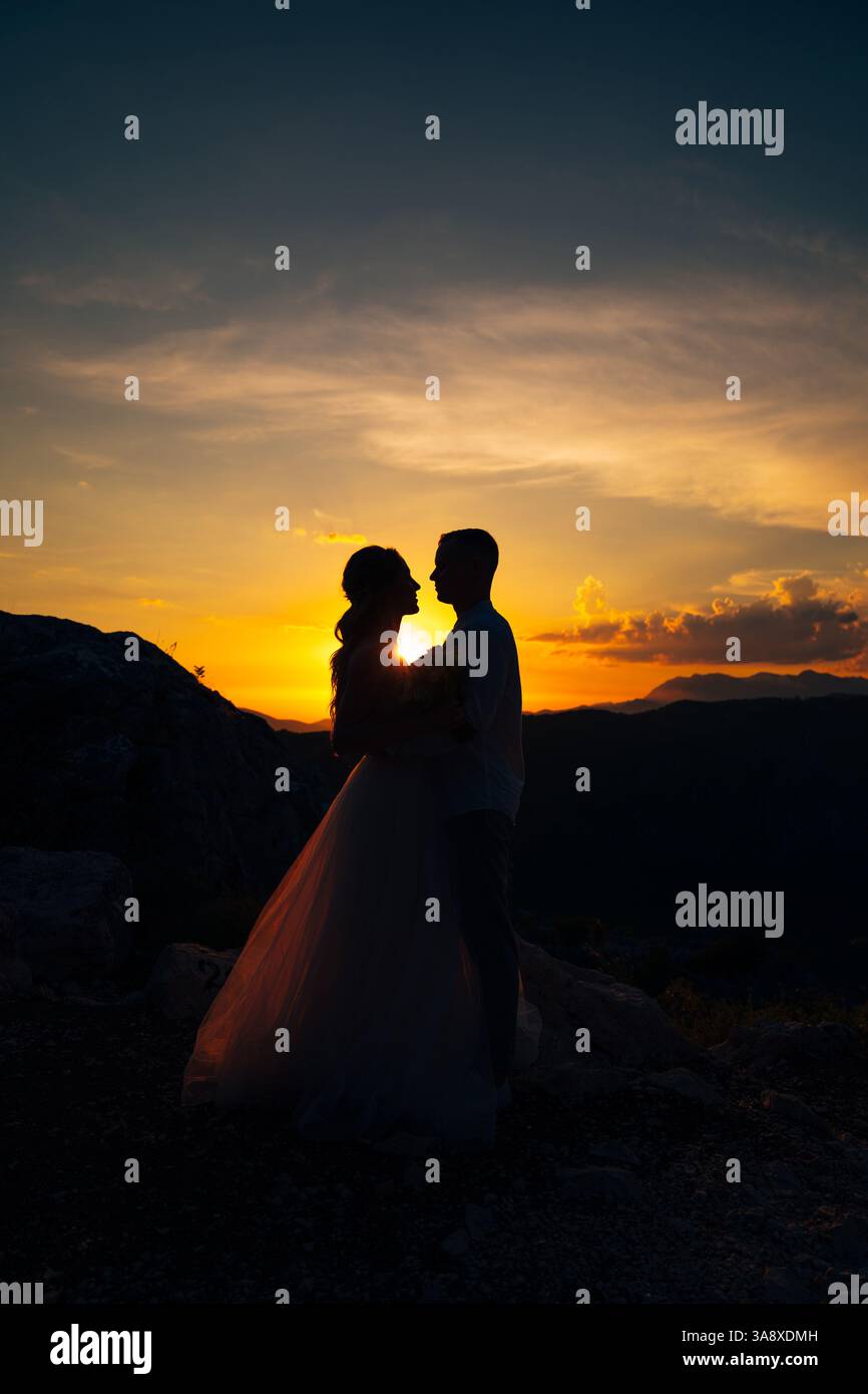 Silhouettes of the bride and groom standing opposite each other on the ...