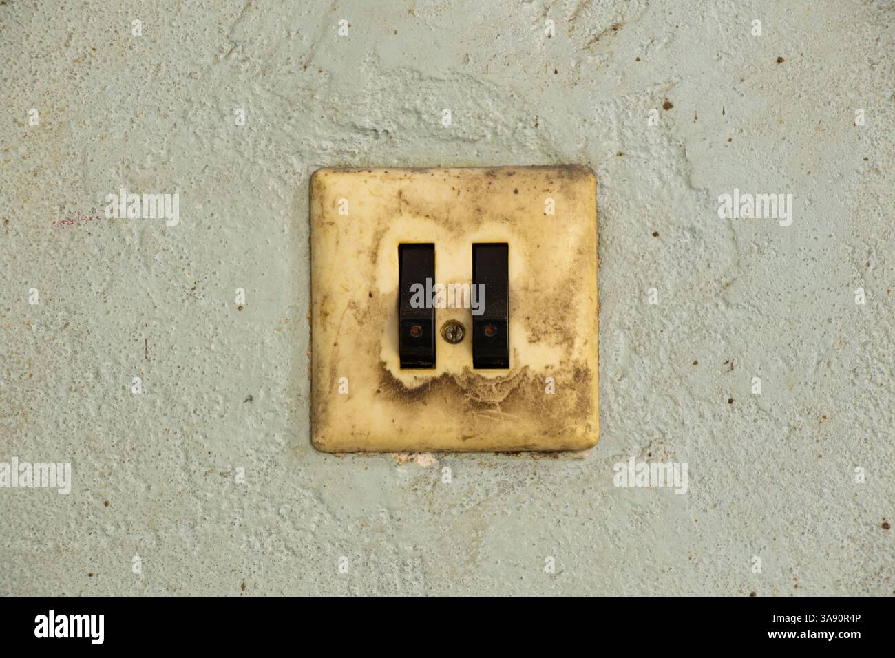 Old dirty double switch on old wall in workshop, wall switch Stock Photo