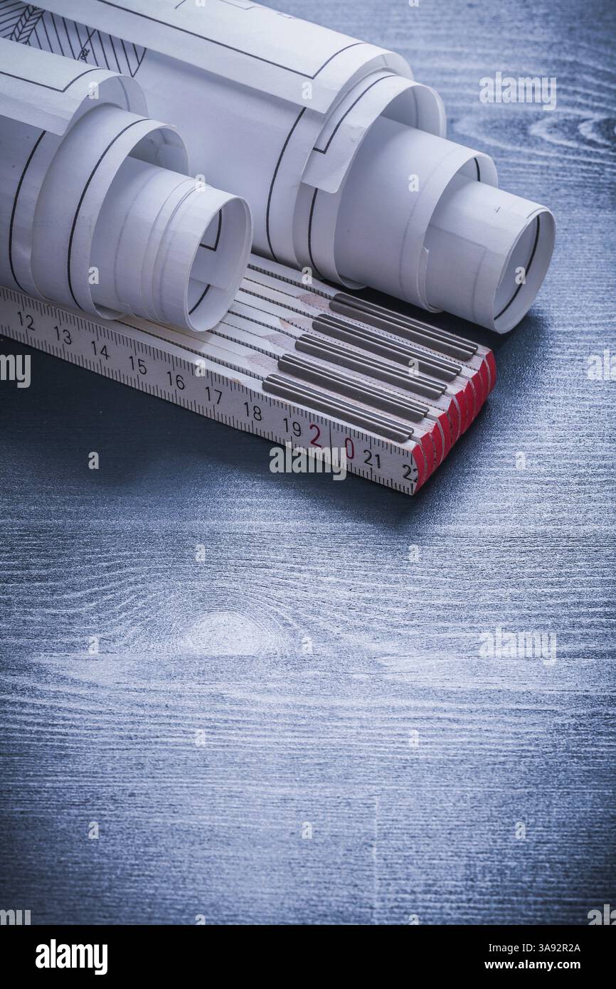 Vertical view two rolled up white blueprints and wooden meter Stock ...