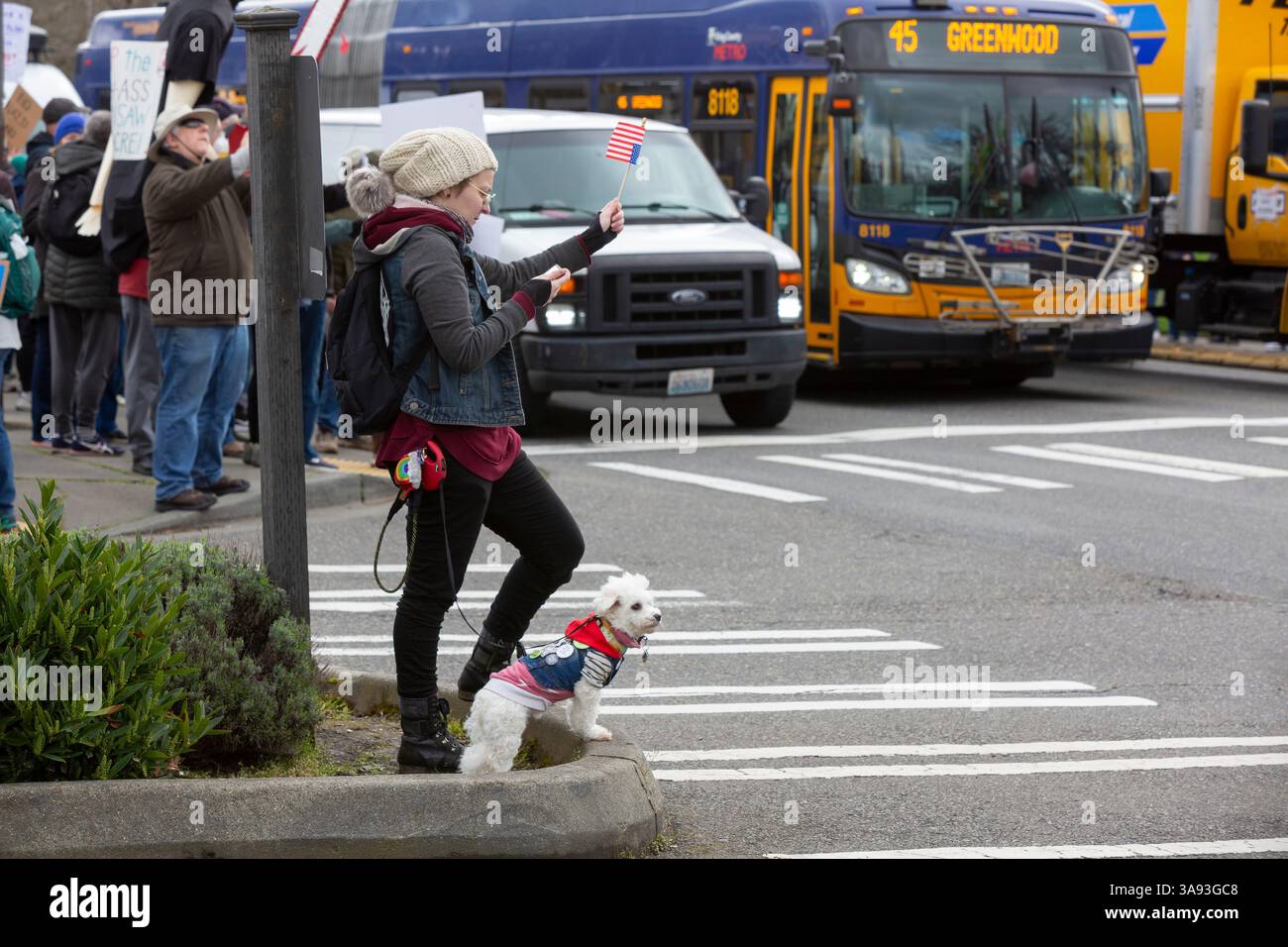 Seattle, Washington, USA. 29th March, 2025. A woman reads a chant as protesters gather along NE 45th Street. The Tesla Takedown Rally, part of a Global Day of Action, is a protest against Elon Musk and the Donald Trump administration. Credit: Paul Christian Gordon/Alamy Live News Stock Photo