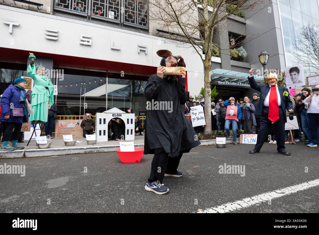 Seattle, Washington, USA. 29th March, 2025. A group of self-professed “Seattle troublemakers” perform a skit at the University Village Tesla showroom. The Tesla Takedown Rally, part of a Global Day of Action, is a protest against Elon Musk and the Donald Trump administration. Credit: Paul Christian Gordon/Alamy Live News Stock Photo
