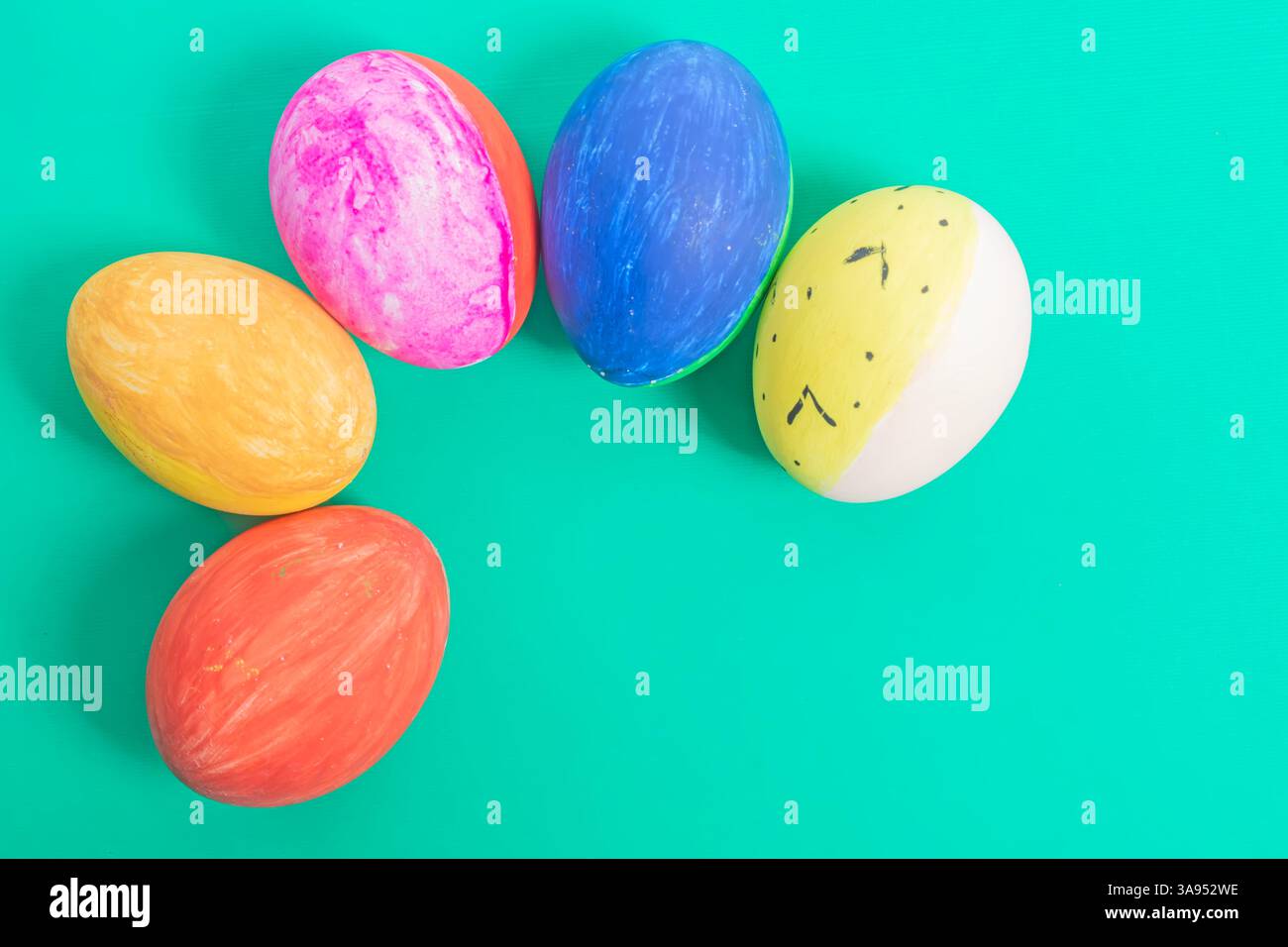 Brightly colored and decorated Easter eggs, illustrated on a solid green surface, evoke a festive atmosphere and holiday cheer. Stock Photo