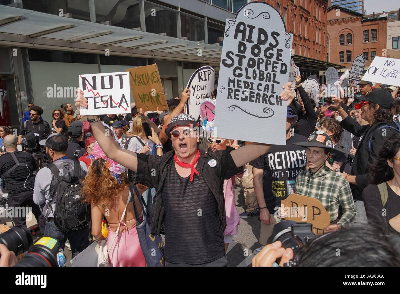 People hold up tombstone signs during the'TeslaTakedown' protest ...