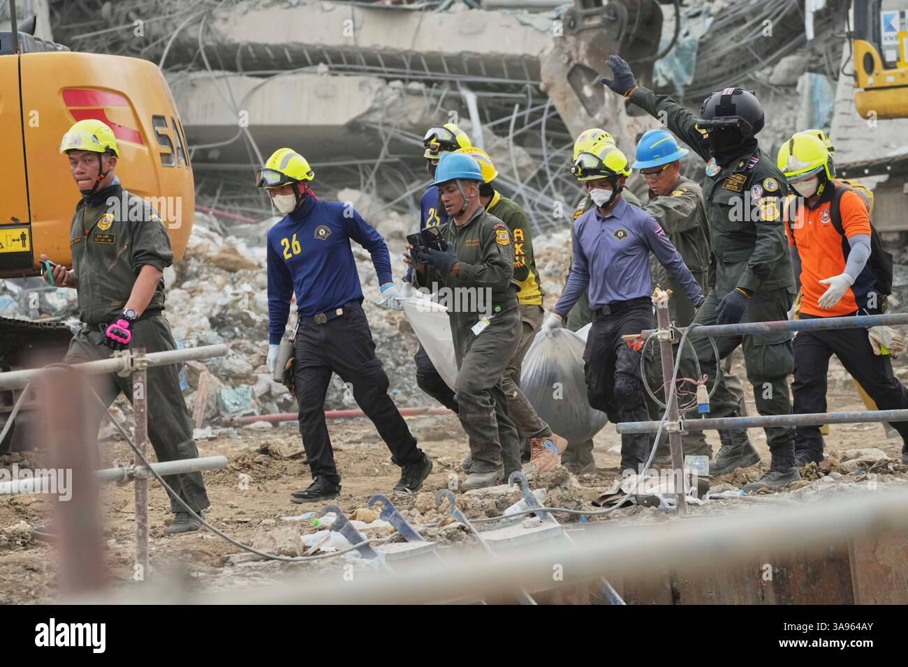 Rescuers carry a body of a worker from the site of an under ...