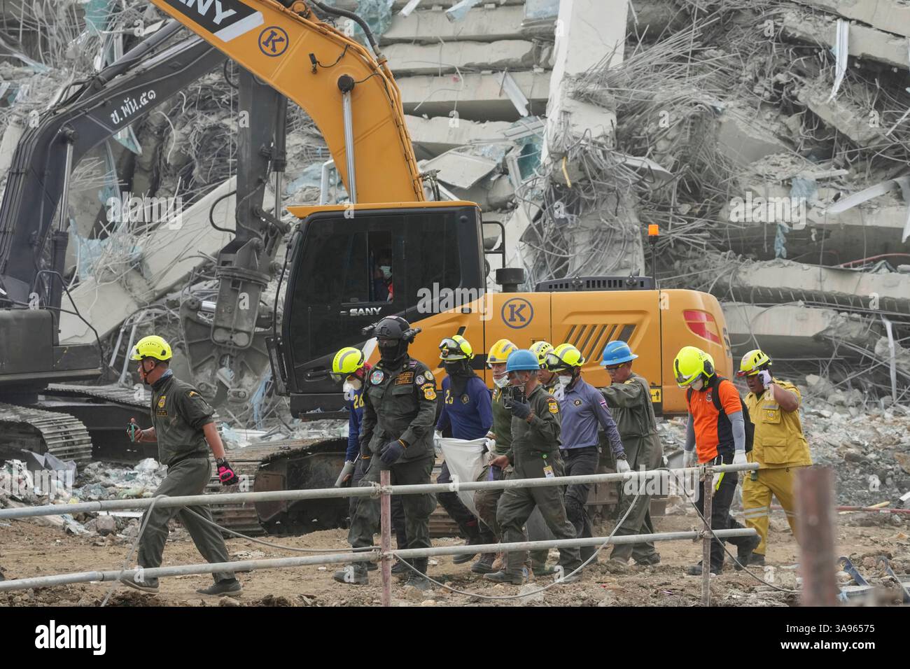 Rescuers carry a body of a worker from the site of an under ...