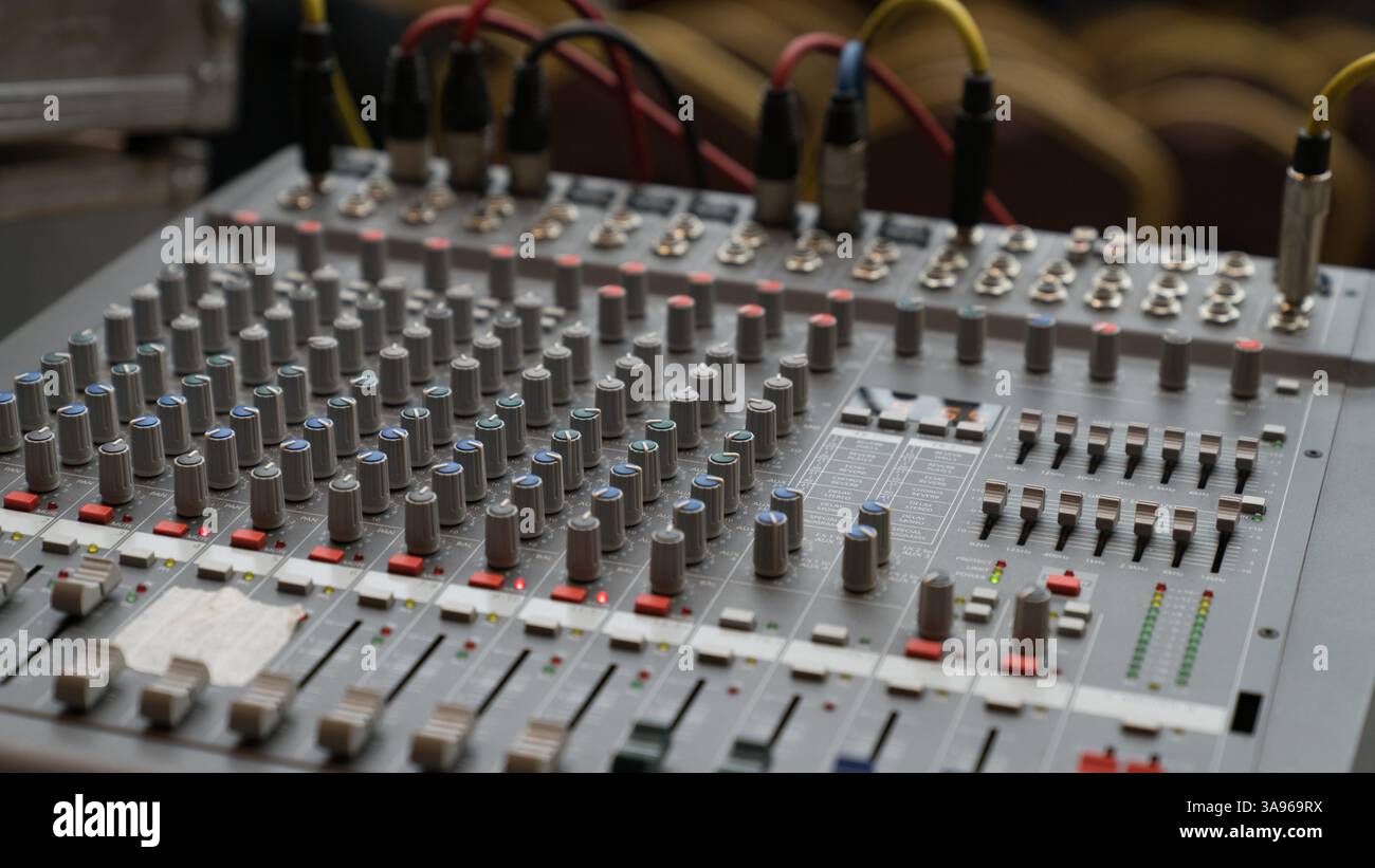 A professional audio mixing console with multiple knobs, buttons, and sliders, used for sound control in music production, broadcasting, and live even Stock Photo