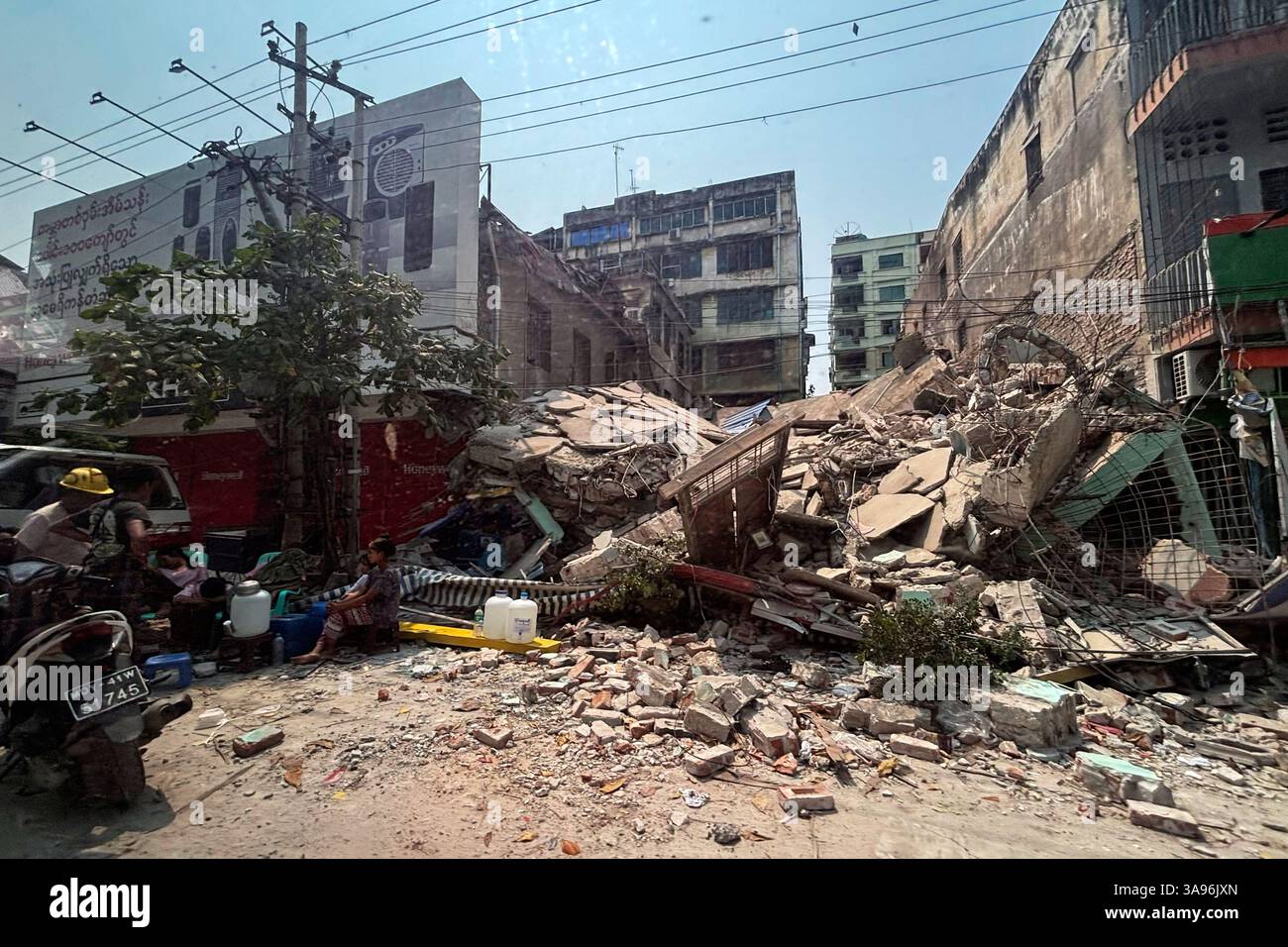 Local residents rest near a damaged building in the aftermath of an ...