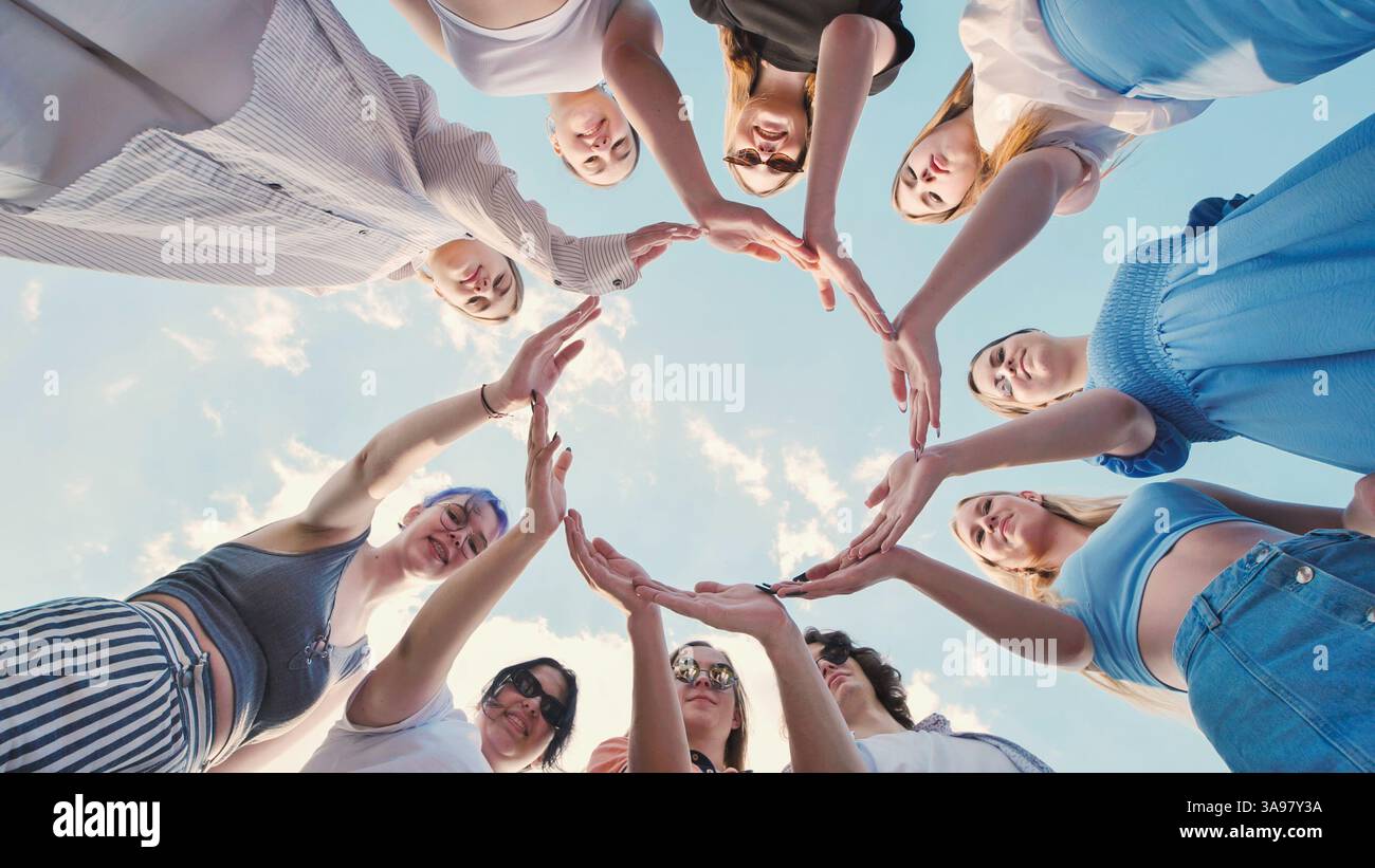Group of school friends forming a circle with their hands against a ...